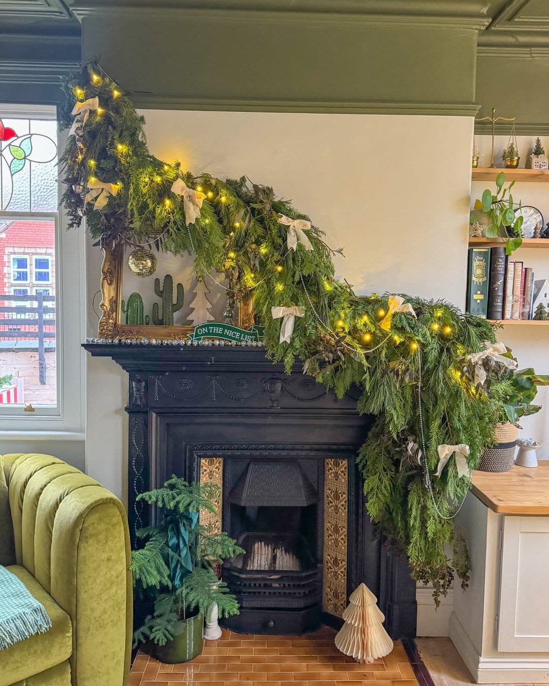Evergreen fireplace garland with lights and bows among christmas garland ideas