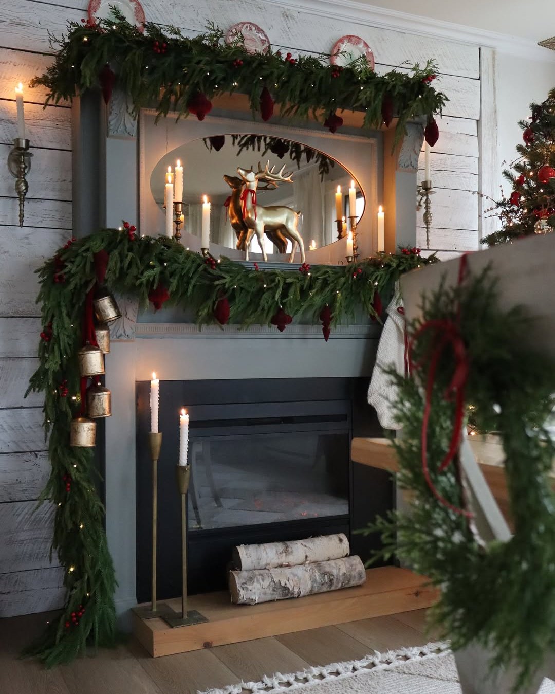 Evergreen fireplace christmas garland ideas with stockings, berries, bells, and glowing lights