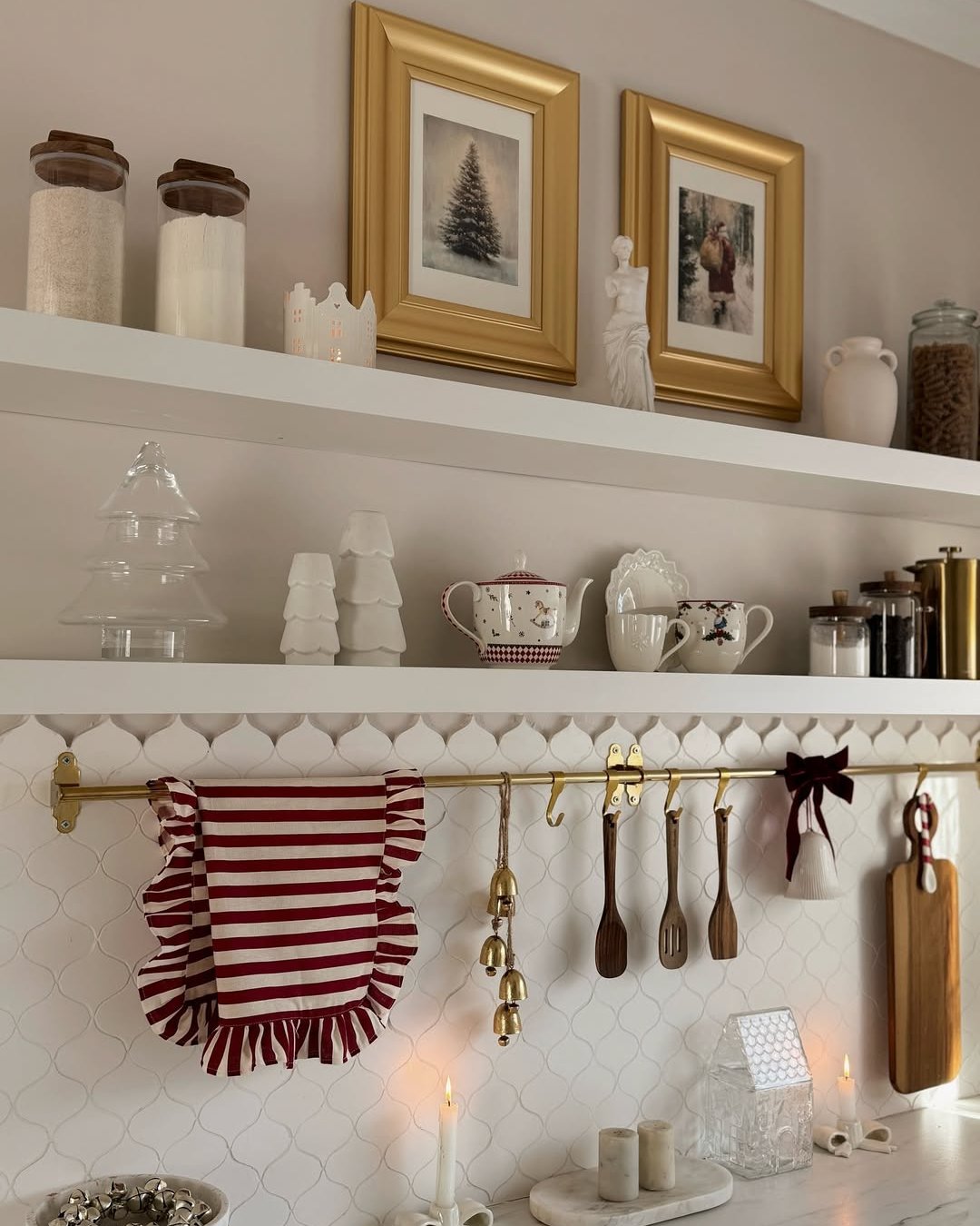 Christmas kitchen decor ideas with striped apron, festive mugs, ceramic trees, brass hooks, and warm candlelight