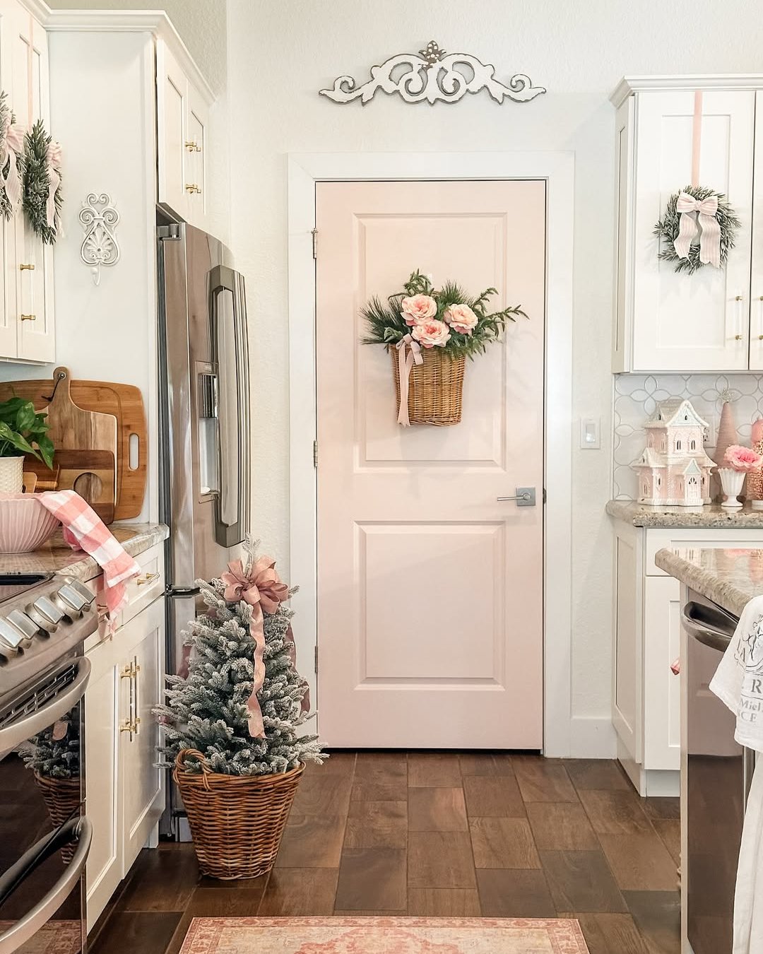 Pastel Christmas kitchen with pink floral basket, frosted tree, wreaths, and cottage accents