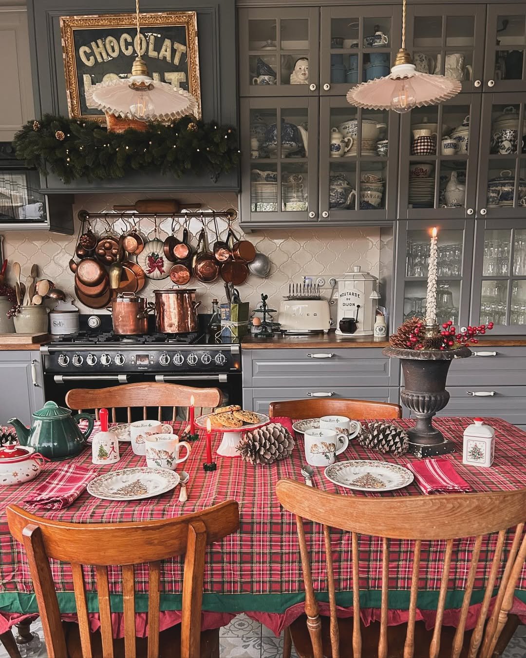 Plaid Christmas kitchen with copper pans, evergreen garland, vintage dishware, and festive dining table