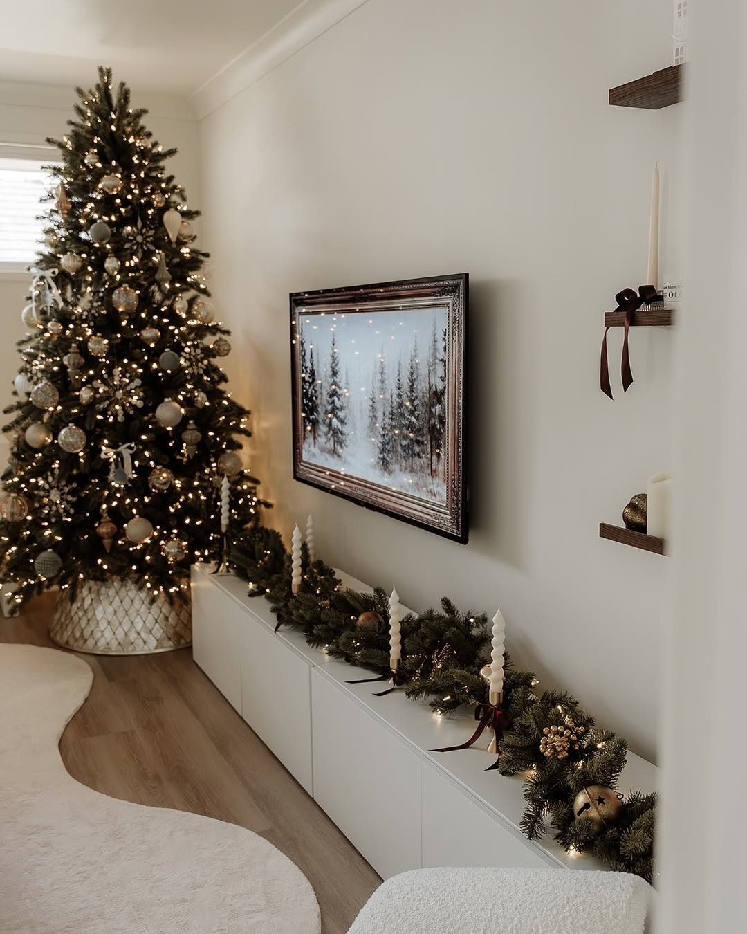 Christmas living room with glowing tree, evergreen console garland, candles, and neutral ornaments