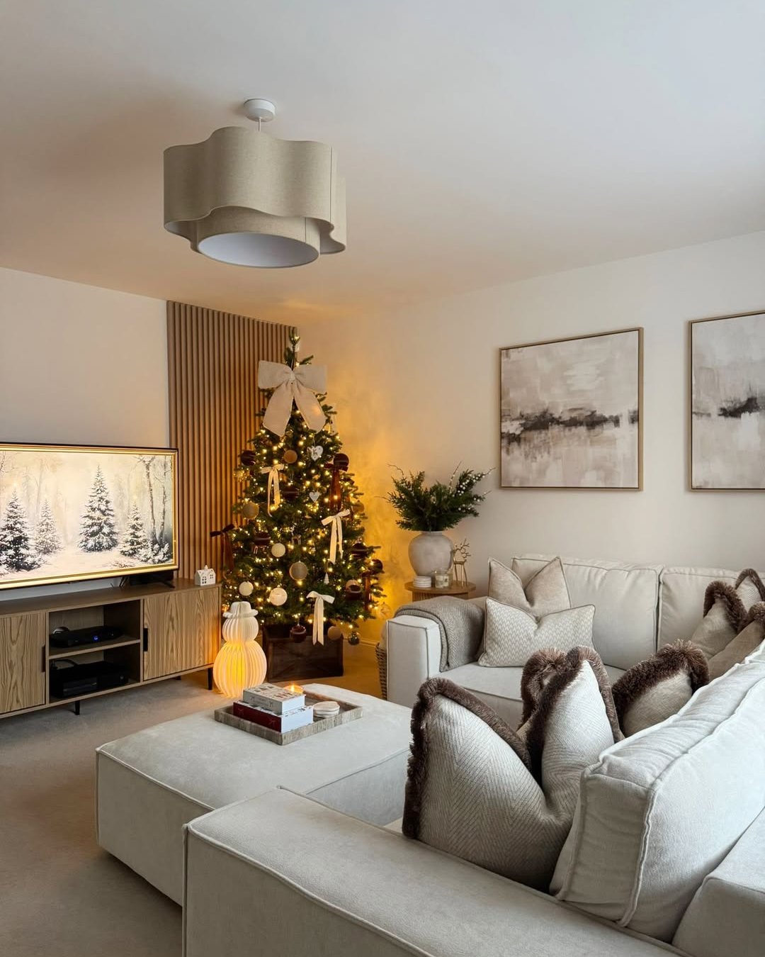 christmas living room decor ideas featuring a neutral ribbon tree and cozy cream seating