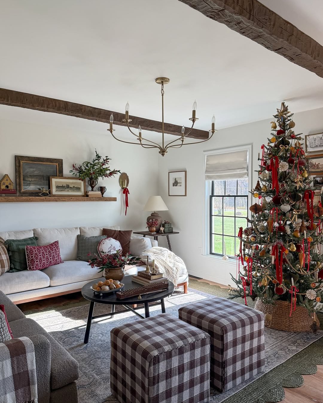Traditional Christmas living room with ribbon-filled tree, plaid ottomans, woven textures, and rustic wood accents