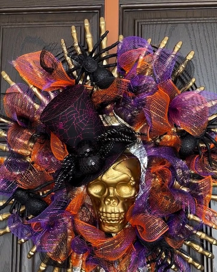 Layered purple and orange mesh Halloween wreath with gold skull, skeleton hands, black spiders, and witch hat