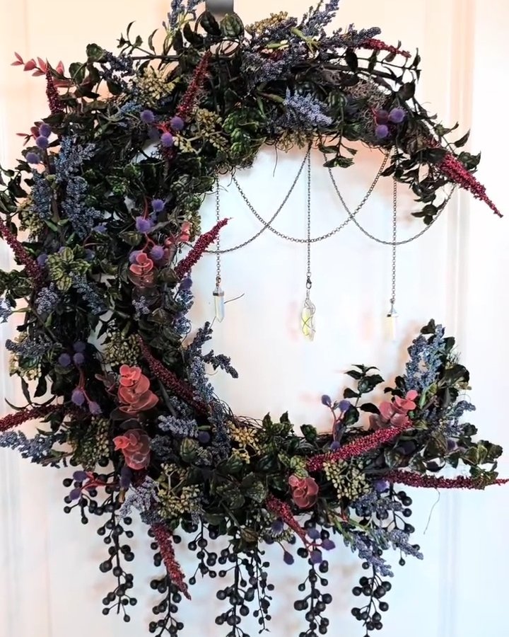 Dark botanical Halloween wreath with purple flowers, black berries, cascading chains, and crystal ornaments