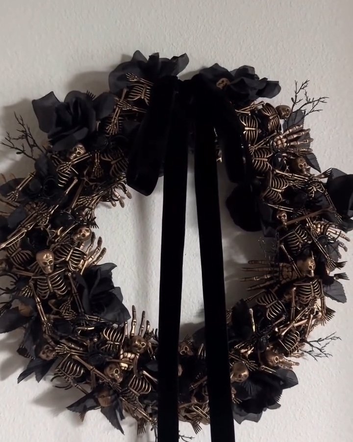 Black skeleton wreath with oversized velvet bow and spooky botanical accents