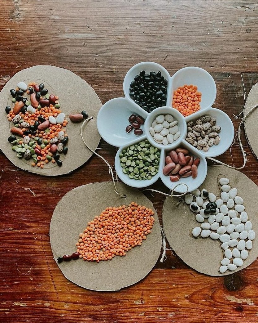 Children's autumn bean mosaics on cardboard leaves with colorful legumes and twine