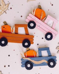 Colorful popsicle stick pumpkin trucks for a cheerful autumn children's craft
