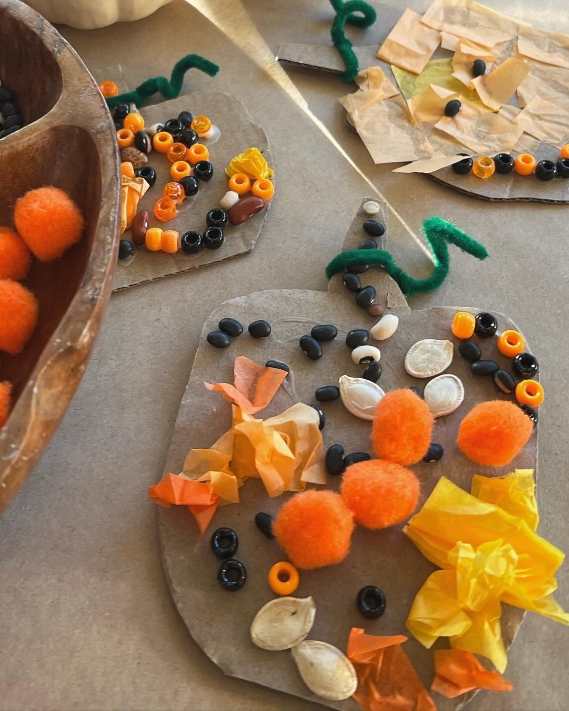 Colorful textured pumpkin collages made with cardboard, pom-poms, tissue paper, beads, seeds, and pipe cleaners