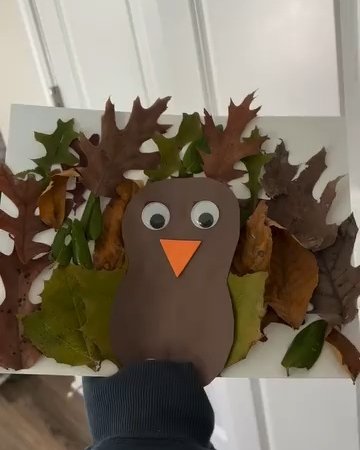 Paper turkey surrounded by colorful autumn leaves for a playful seasonal kids' craft