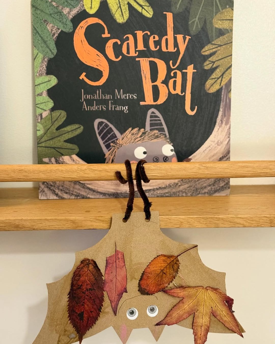 Autumn leaf hedgehog craft hanging beneath a wooden dowel