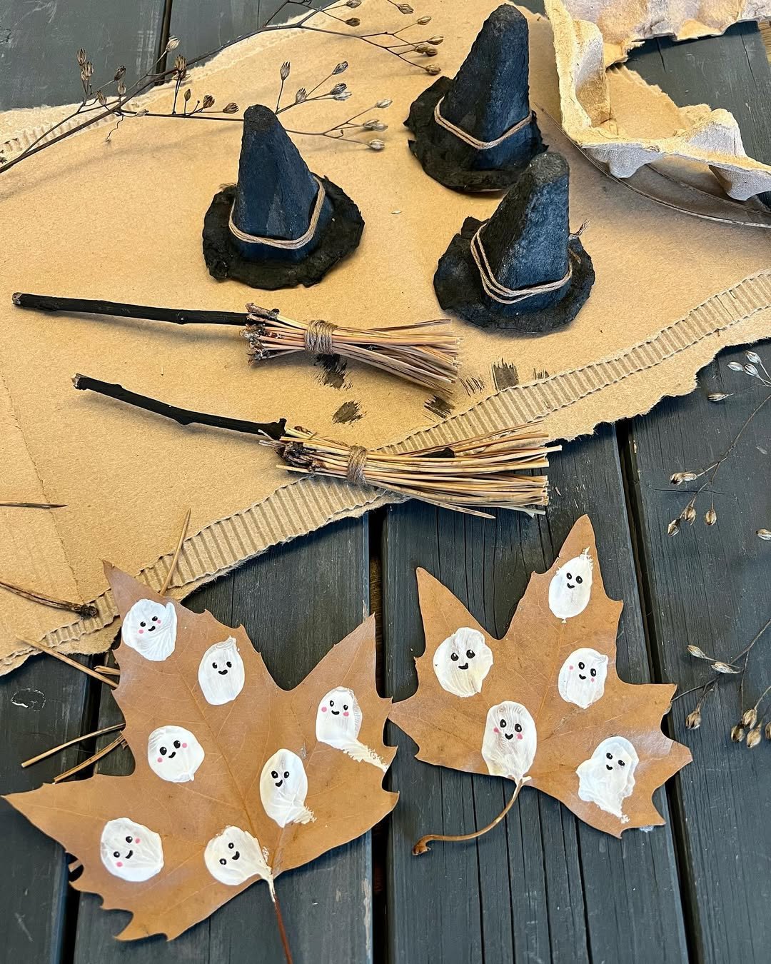 White painted leaf ghosts, tiny witch hats, and twig brooms for a playful autumn craft activity