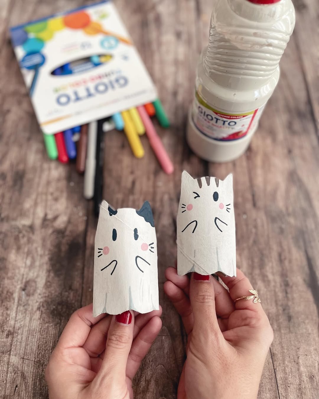 Handmade Halloween cat puppets crafted from painted toilet paper rolls