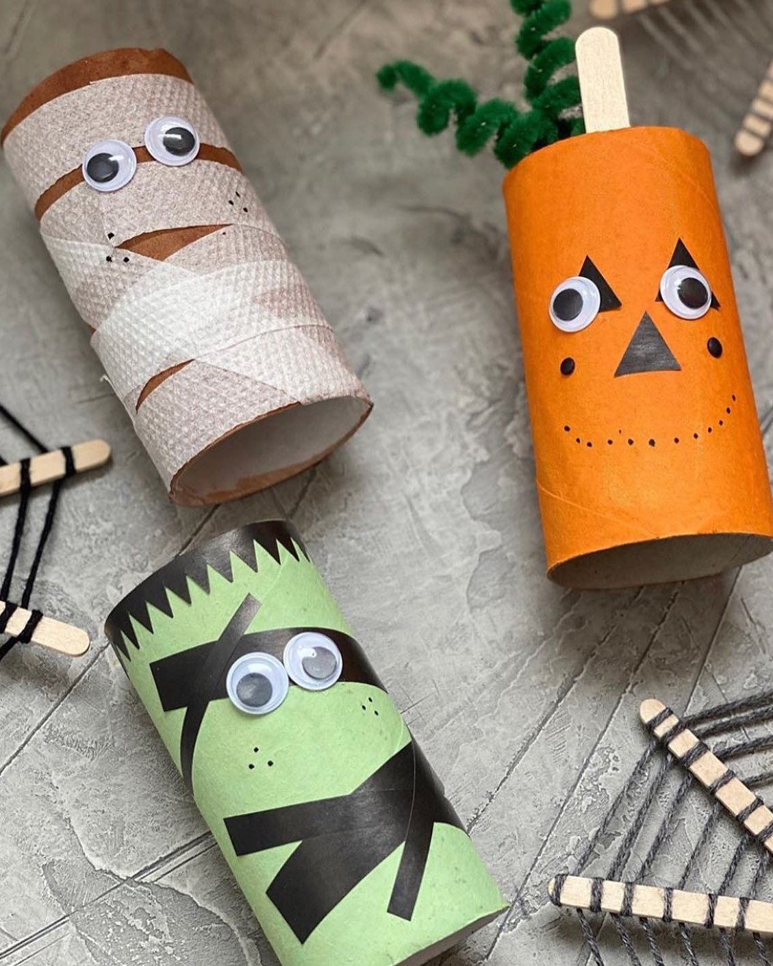 Colorful cardboard tube Halloween characters with googly eyes, including a mummy, pumpkin, and Frankenstein monster