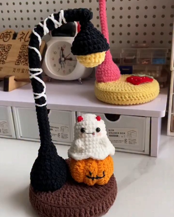 Cute Halloween crochet witch hat, pumpkin, and ghost decorations on a rounded handmade base