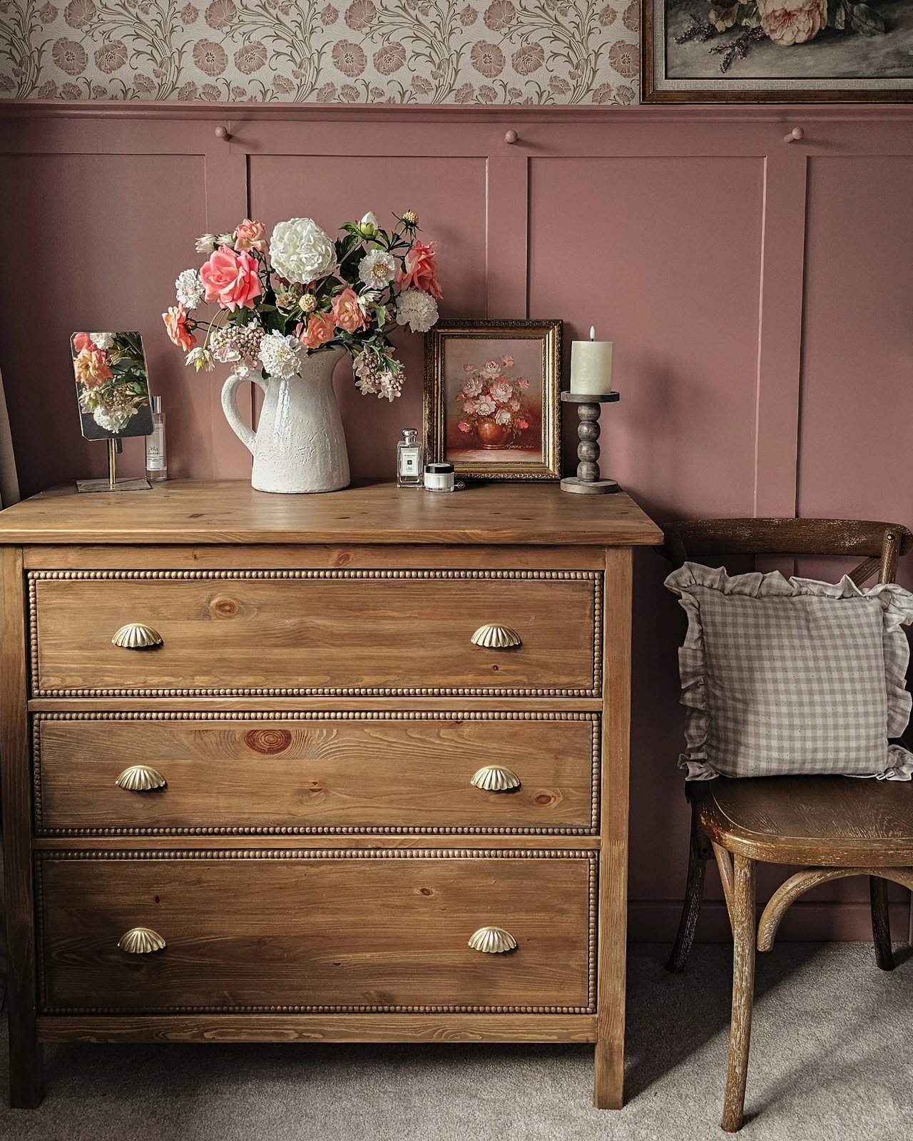 Bobbin-trimmed Hemnes dresser with wood stain, scalloped pulls, flowers, and vintage bedroom styling