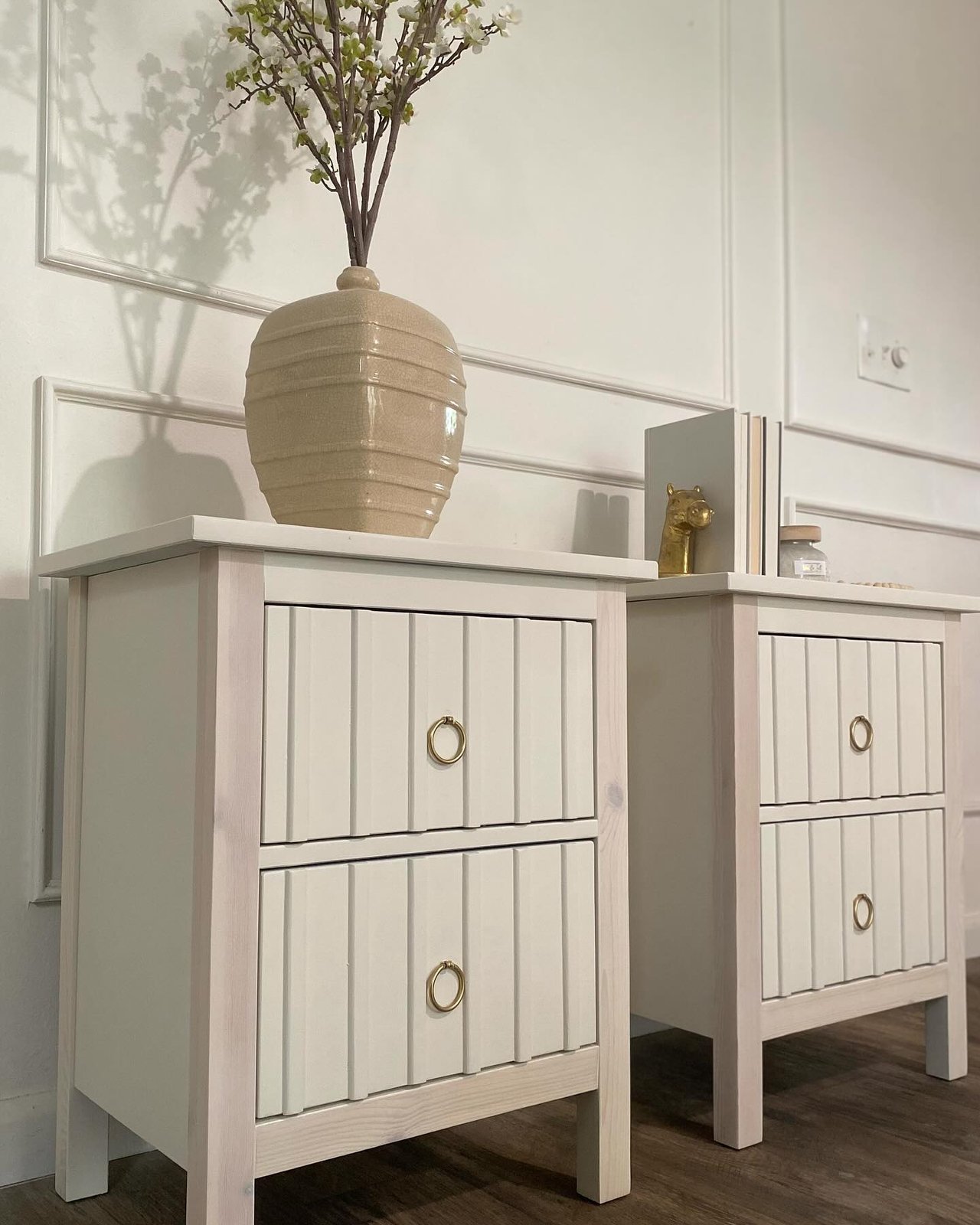 Fluted HEMNES nightstands with ring pulls and an ivory finish beside a paneled wall