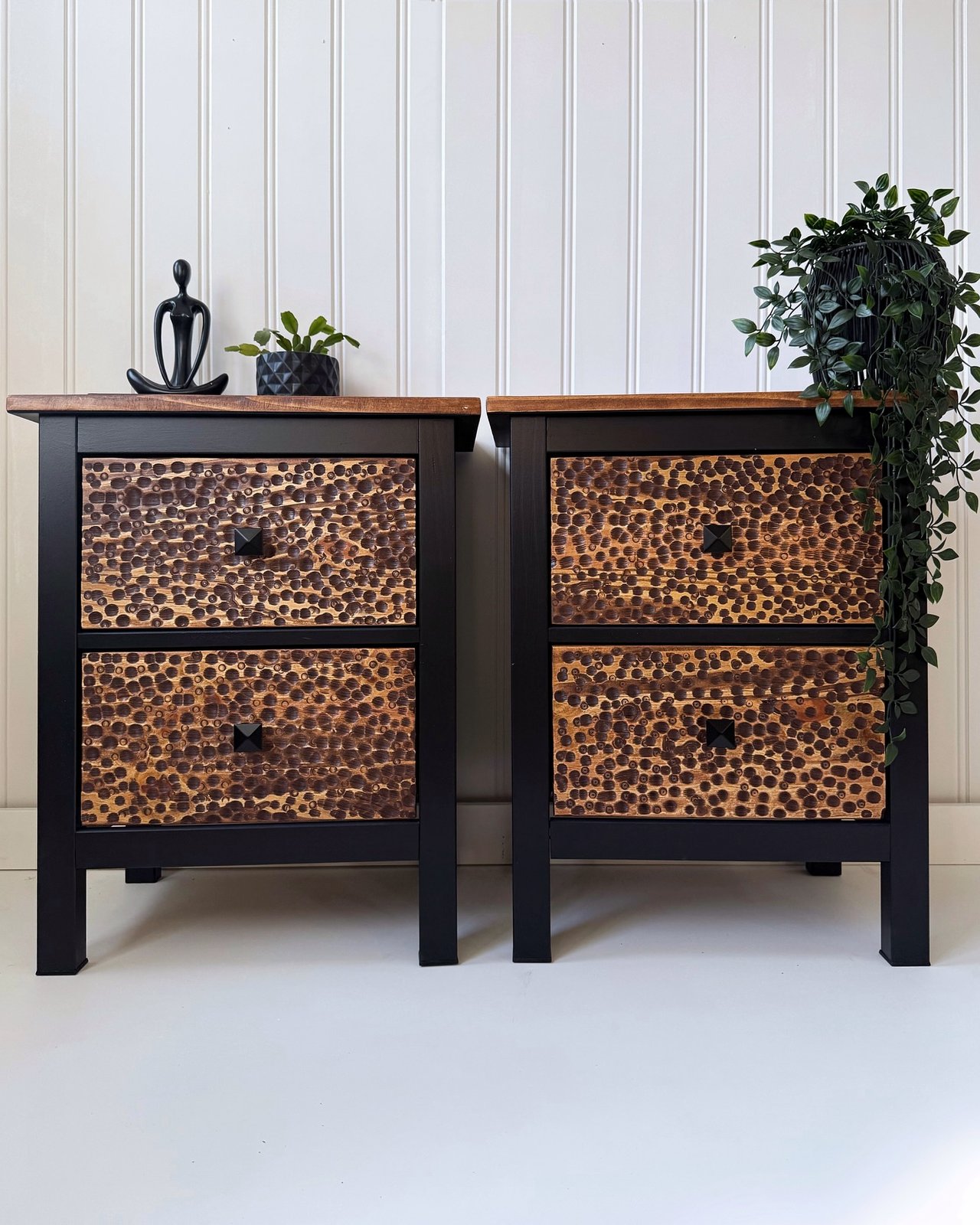 Black HEMNES nightstands with carved wood drawer fronts and warm textured panels