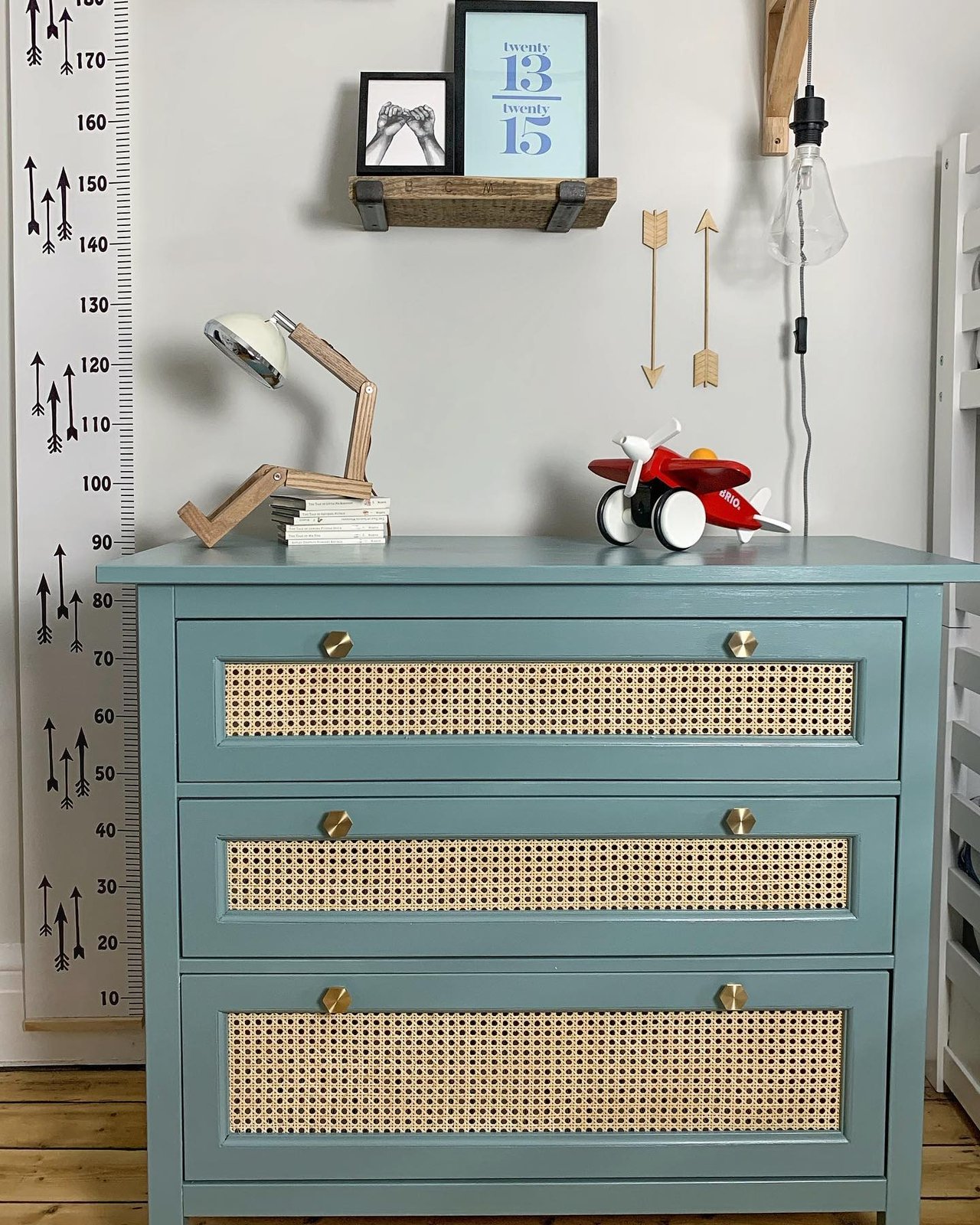 Blue-green Hemnes dresser with cane drawer fronts and brass knobs in a playful child's room