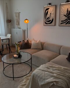 Neutral sofa, textured throw, candlelight, and framed art among winter living room decor ideas