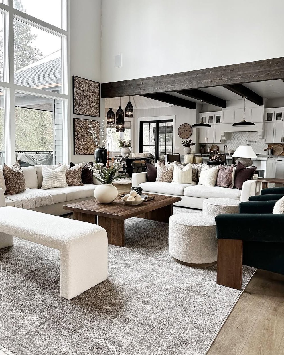Neutral winter living room with layered pillows, wood beams, and cozy seating