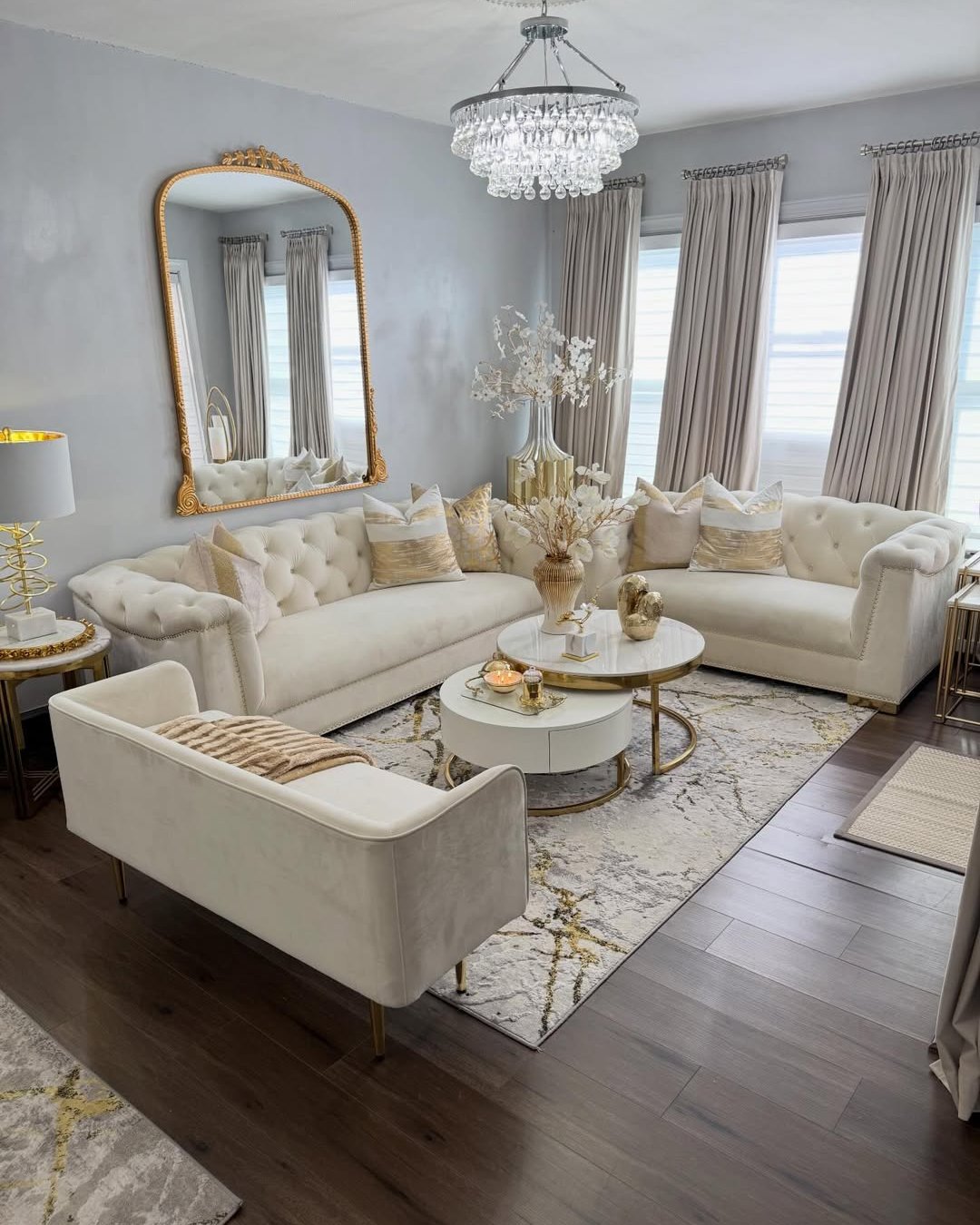 Ivory sectional, crystal chandelier, and frosty floral accents in an elegant seasonal living room