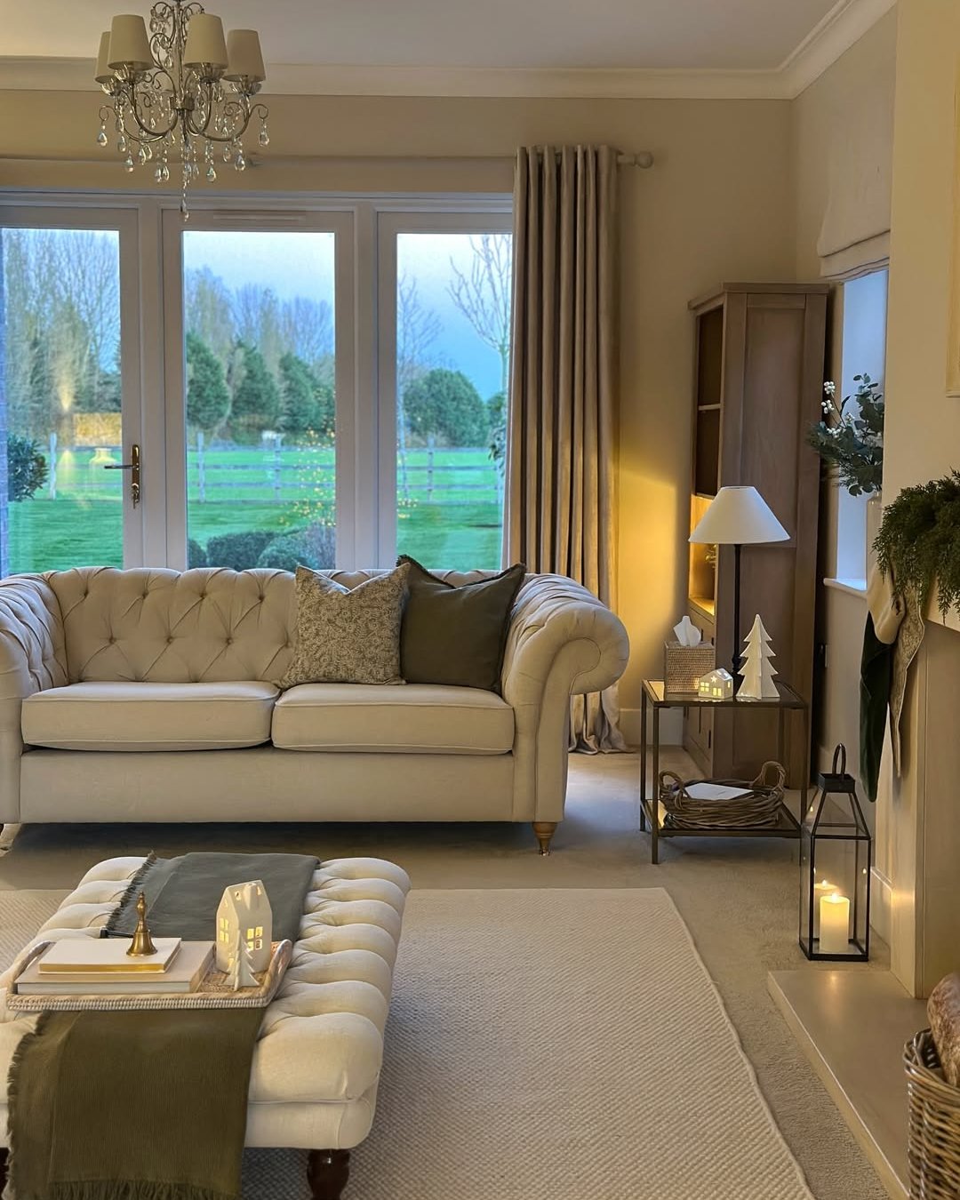 Winter living room decor ideas featuring neutral textiles, candles, lanterns, and cozy layered furnishings