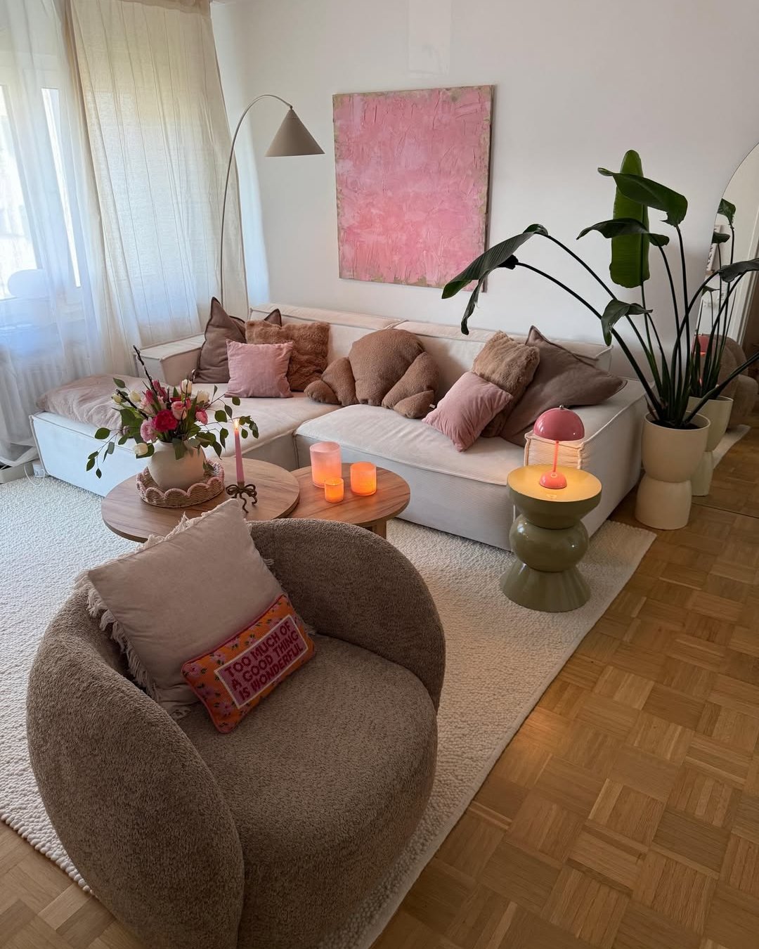 Soft layered living room with plush seating, candles, plants, and warm winter styling