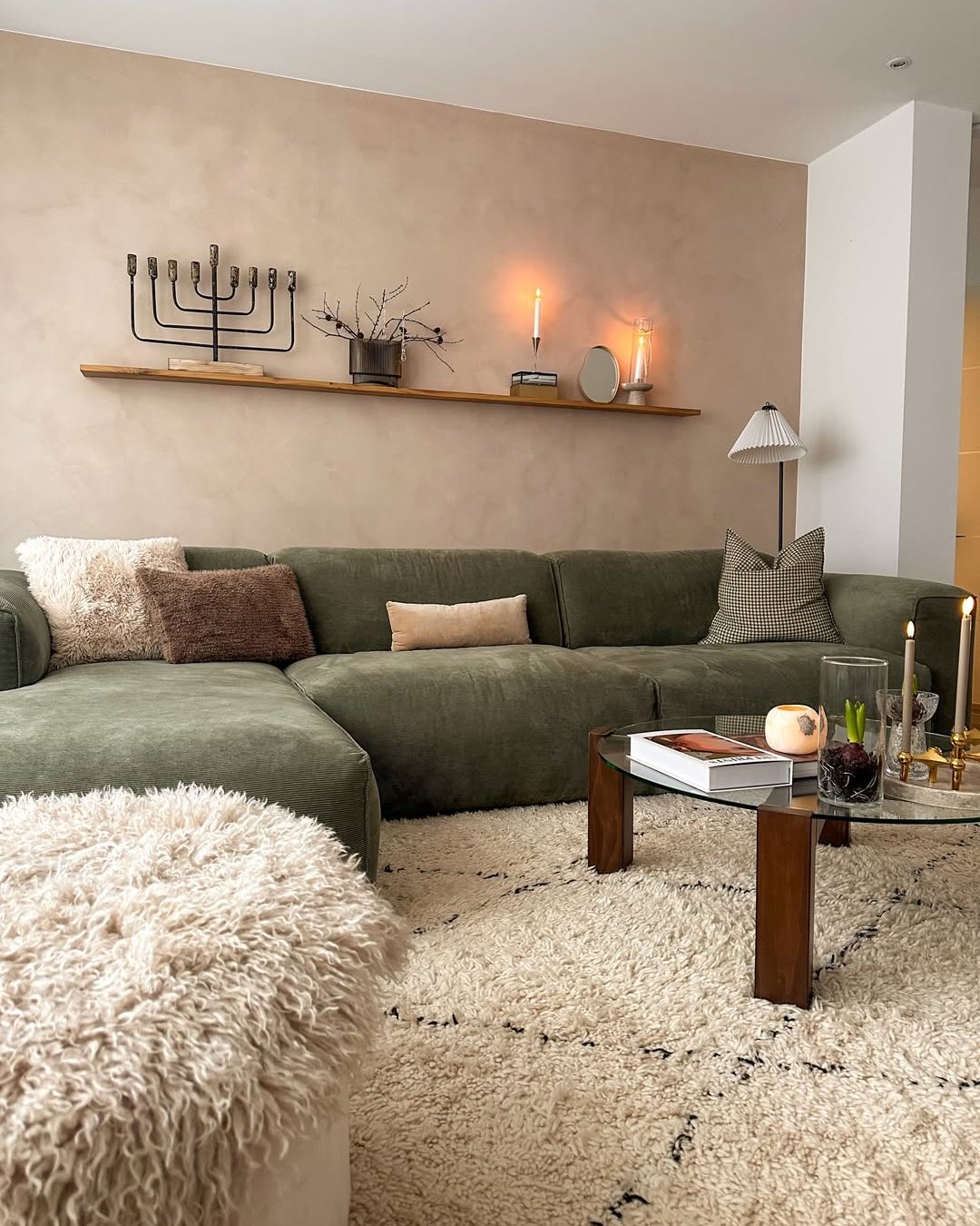 Winter living room decor ideas with an olive sectional, layered ivory textures, candles, and warm wood accents